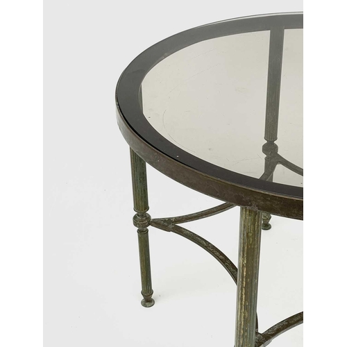 3193 - A glass topped gilt metal circular occasional table, raised on turned and fluted legs united by conc... 