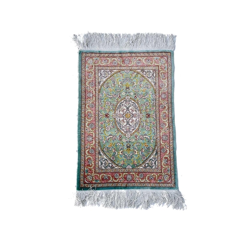 3202 - A Turkish silk rug, the pale blue field with an oval ivory medallion with scrolling flowering leafy ... 