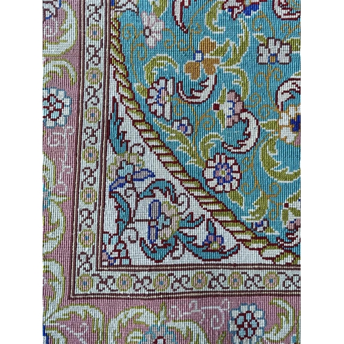 3202 - A Turkish silk rug, the pale blue field with an oval ivory medallion with scrolling flowering leafy ... 