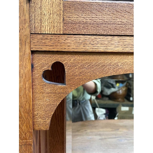 3206 - An Arts & Crafts oak sideboard, the upper part fitted with two glazed doors, the base with two bow f... 