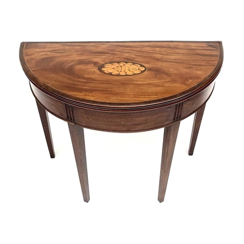 3217 - A George III mahogany demi lune fold over card table, the top with a shell inlaid oval panel and ros... 