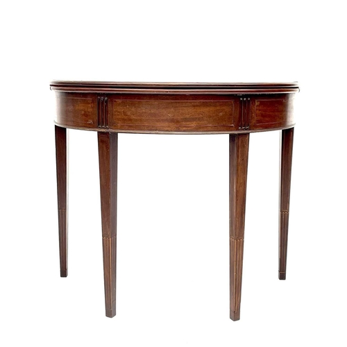 3217 - A George III mahogany demi lune fold over card table, the top with a shell inlaid oval panel and ros... 