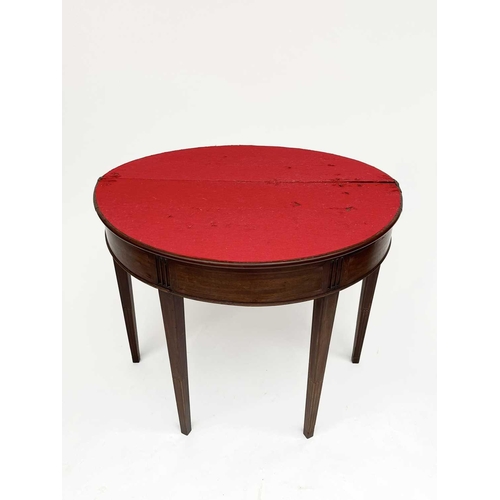 3217 - A George III mahogany demi lune fold over card table, the top with a shell inlaid oval panel and ros... 