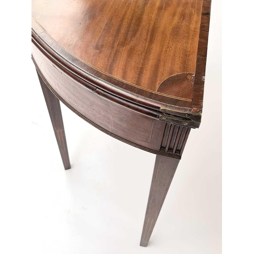 3217 - A George III mahogany demi lune fold over card table, the top with a shell inlaid oval panel and ros... 