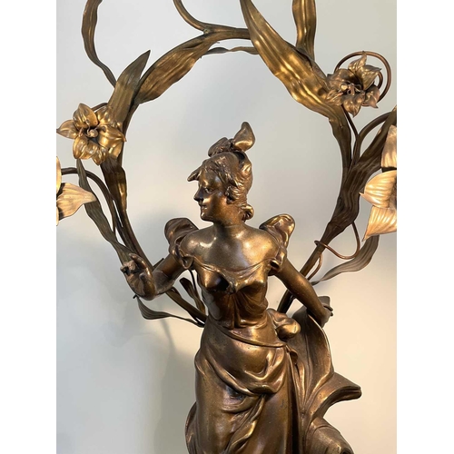 338 - A French Art Nouveau gilt spelter table lamp, modelled as a lady standing on a foliate base, the lea... 