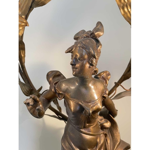 338 - A French Art Nouveau gilt spelter table lamp, modelled as a lady standing on a foliate base, the lea... 