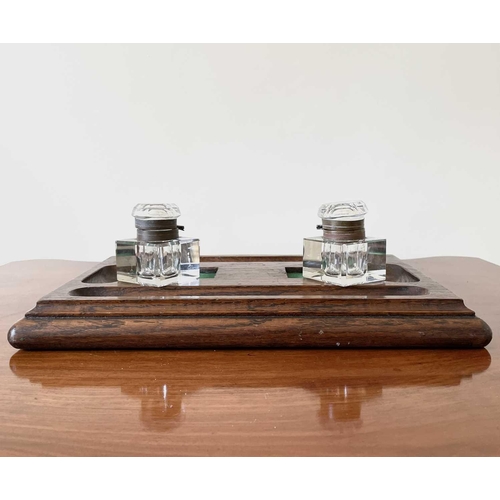 342 - An oak deskstand, circa 1920's, fitted with two glass inkwells, width 26cm.