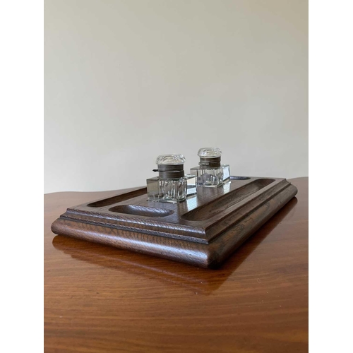 342 - An oak deskstand, circa 1920's, fitted with two glass inkwells, width 26cm.