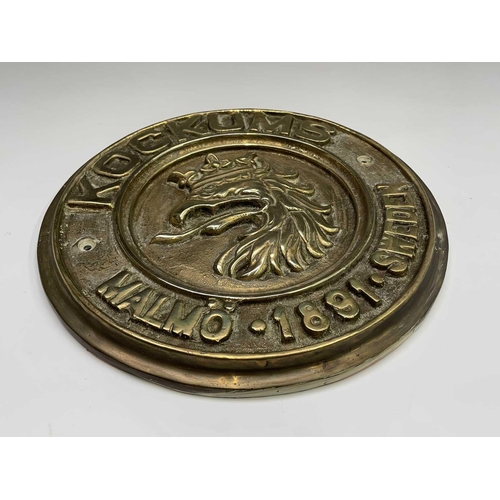 359 - A Swedish brass ship builder's plaque, inscribed Kockums Malmo 1891, diameter 29.5cm.