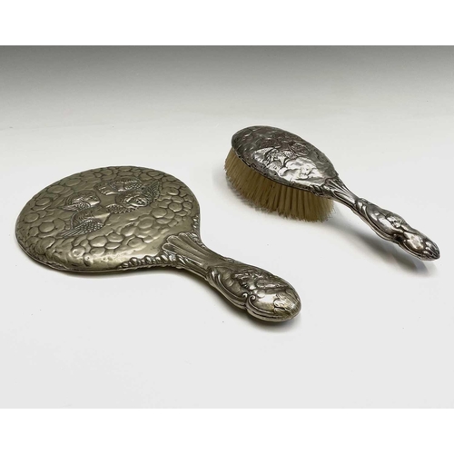 363 - A hallmarked silver-backed hairbrush and a silver-plated hand mirror, both decorated with the 'Reyno... 