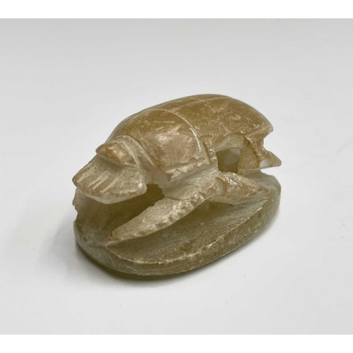 366 - An elaborately carved African nut, height 11.5cm, together with two carved alabaster scarab beetles,... 