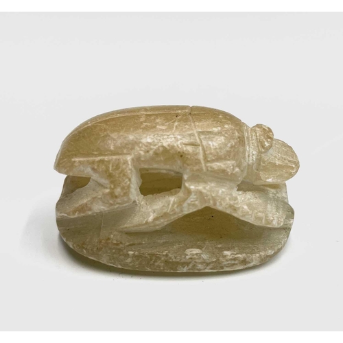 366 - An elaborately carved African nut, height 11.5cm, together with two carved alabaster scarab beetles,... 