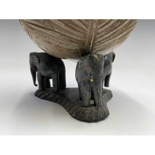 406 - An Indian carved coconut, on elephant stand, height 18cm, together with a carved ethnic figure etc (... 