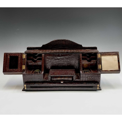 418 - An Asprey & Co crocodile desk stand and writing slope, fitted with two silver gilt mounted inkwells,... 