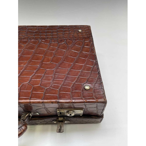 419 - An early 20th century crocodile skin briefcase with fitted interior, the silver plated lock plates m... 