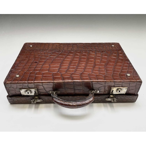 419 - An early 20th century crocodile skin briefcase with fitted interior, the silver plated lock plates m... 