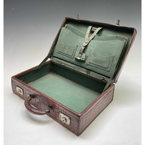 419 - An early 20th century crocodile skin briefcase with fitted interior, the silver plated lock plates m... 