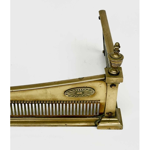 430 - An Edwardian brass fender, with urn finials and applied paterae, width 126cm, depth 31cm.