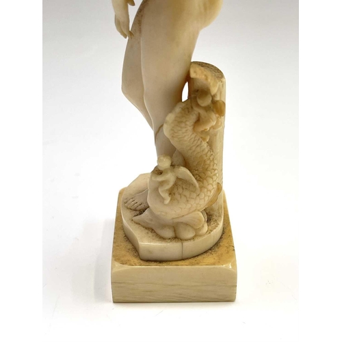 473 - A 19th century French carved ivory figure of Eve, standing beside cherubs playing on a dolphin, heig... 