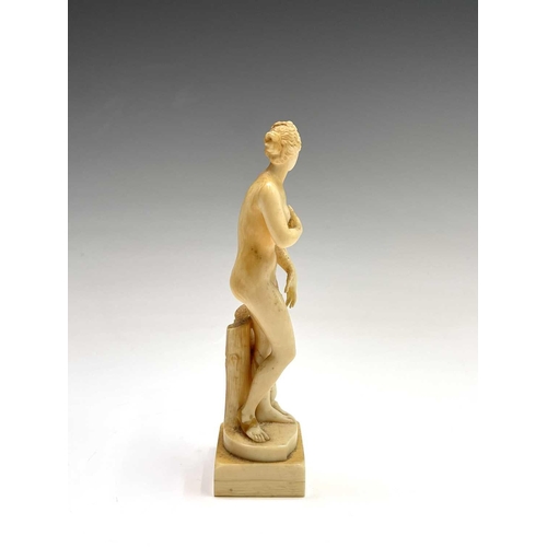 473 - A 19th century French carved ivory figure of Eve, standing beside cherubs playing on a dolphin, heig... 