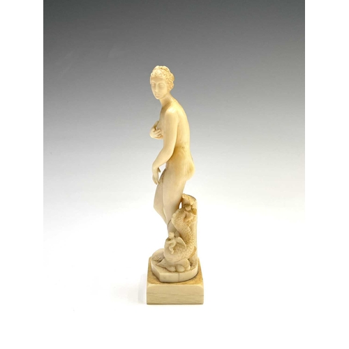 473 - A 19th century French carved ivory figure of Eve, standing beside cherubs playing on a dolphin, heig... 