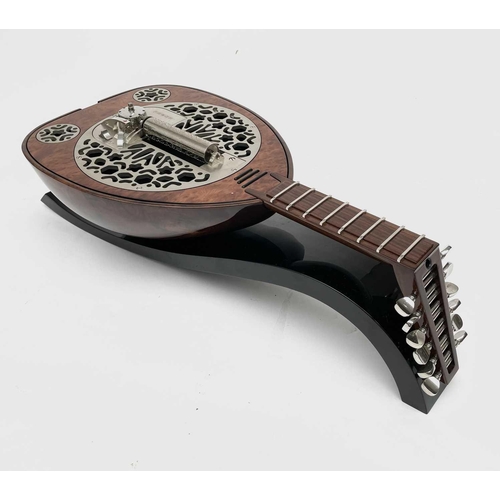 478 - A Rare Reuge music box, in the form of a lute, complete with manual and fitted box. This was given a... 