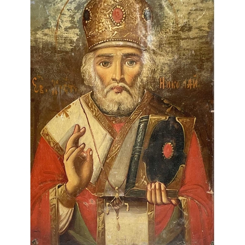 48 - A Russian softwood icon, circa 1900, painted with St Nicholas, holding a bible, 23cm X 16.5cm