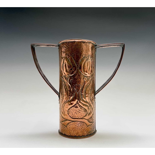 58 - An Arts & Crafts period copper twin handled vase, the cylindrical body repousse decorated with styli... 