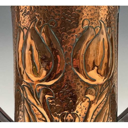 58 - An Arts & Crafts period copper twin handled vase, the cylindrical body repousse decorated with styli... 