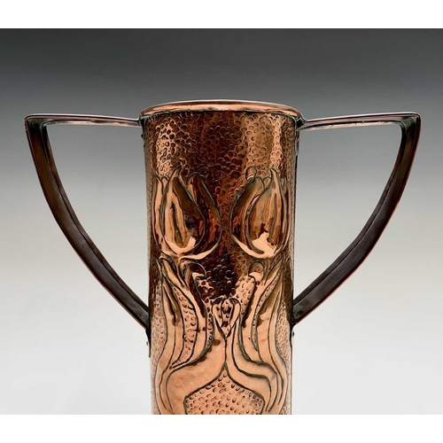 58 - An Arts & Crafts period copper twin handled vase, the cylindrical body repousse decorated with styli... 