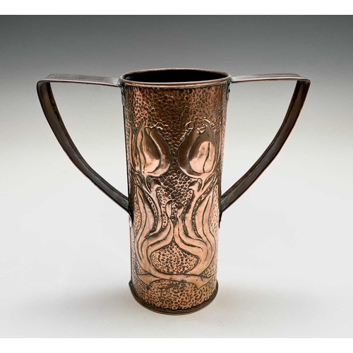 58 - An Arts & Crafts period copper twin handled vase, the cylindrical body repousse decorated with styli... 