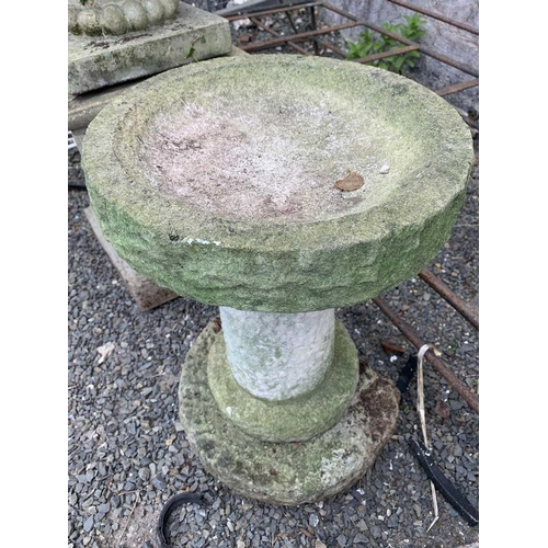 606 - A composition stone bird bath, the circular top raised on a column with stepped base. Overall height... 