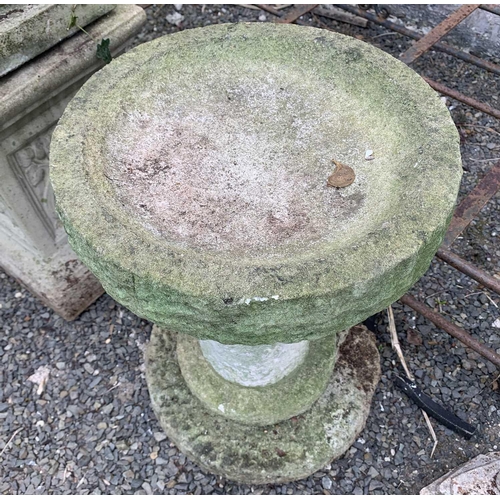 606 - A composition stone bird bath, the circular top raised on a column with stepped base. Overall height... 