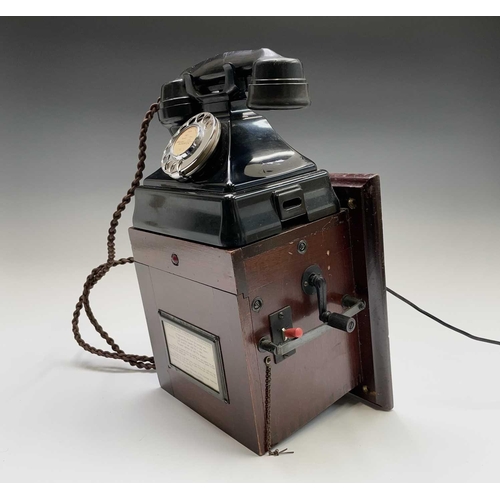 61 - A black bakelite GPO fire emergency telephone, fitted with a mahogany cased dynamo with a winding ha... 