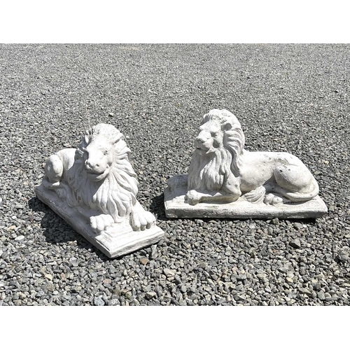 610 - A pair of white painted composition stone recumbent lion garden ornaments. Height 35cm, width 58cm, ... 