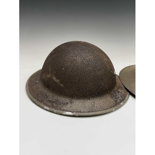 80 - A WWII steel helmet, painted khaki, the liner stamped BMB 1942, with webbing chin strap, together wi... 