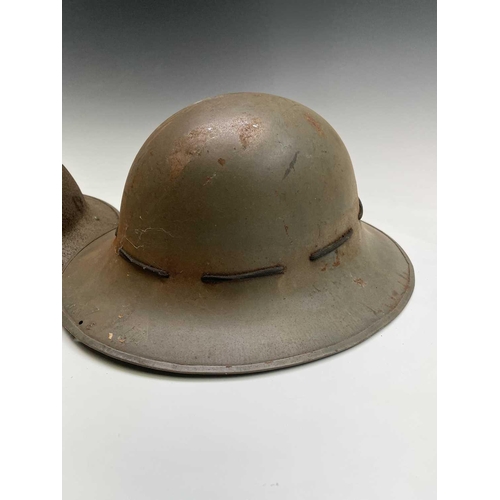 80 - A WWII steel helmet, painted khaki, the liner stamped BMB 1942, with webbing chin strap, together wi... 