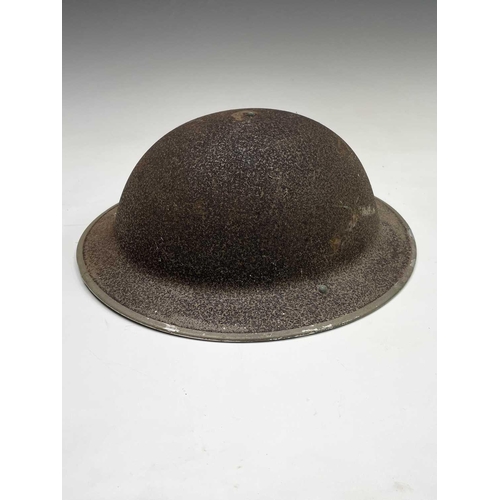 80 - A WWII steel helmet, painted khaki, the liner stamped BMB 1942, with webbing chin strap, together wi... 