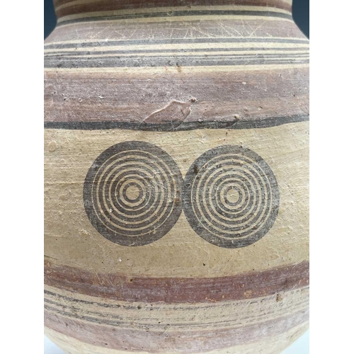 802 - A Cypriot iron age pottery twin handled amphora, with handpainted geometric decoration of bands and ... 