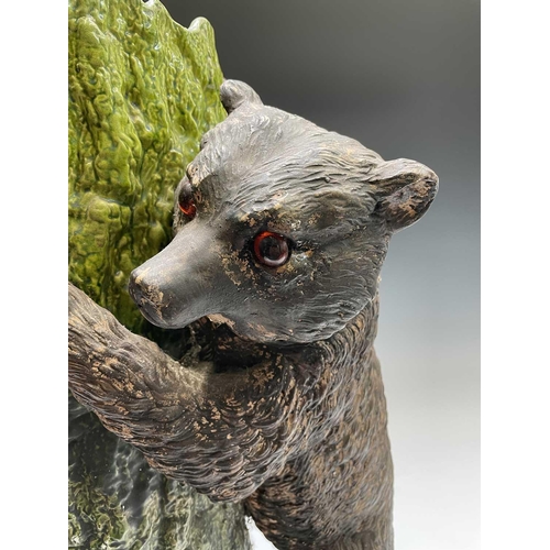 829 - A Bretby pottery stick stand, circa 1900, modelled as a brown bear with inset glass eyes standing be... 