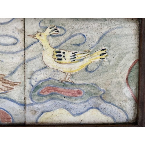 831 - A set of three 20th century ceramic tiles, handpainted with birds, framed. 19cm x 49cm.