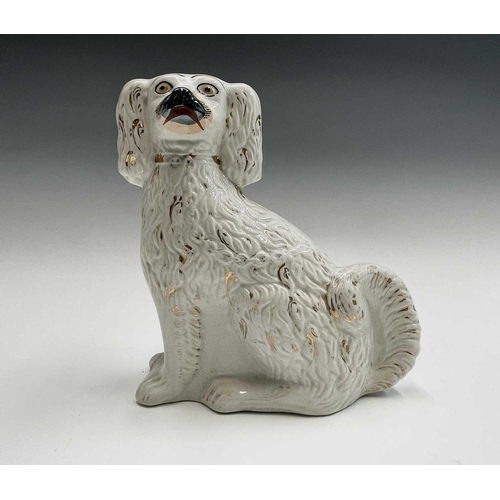 851 - A pair of Victorian Staffordshire pottery figures of spaniels, with gilt decoration and curled tails... 