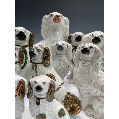 866 - A pair of Victorian pottery figures of spaniels, with green and gilt decoration and separate front l... 