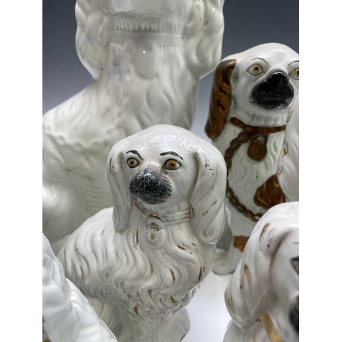 866 - A pair of Victorian pottery figures of spaniels, with green and gilt decoration and separate front l... 