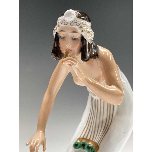 879 - A Rosenthal porcelain figure of a snake charmer, decorated in green and gilt, designed by Berthold B... 