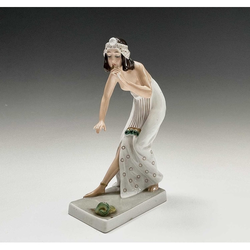 879 - A Rosenthal porcelain figure of a snake charmer, decorated in green and gilt, designed by Berthold B... 