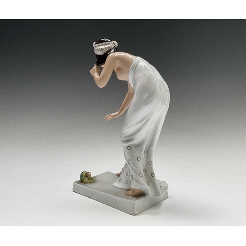 879 - A Rosenthal porcelain figure of a snake charmer, decorated in green and gilt, designed by Berthold B... 