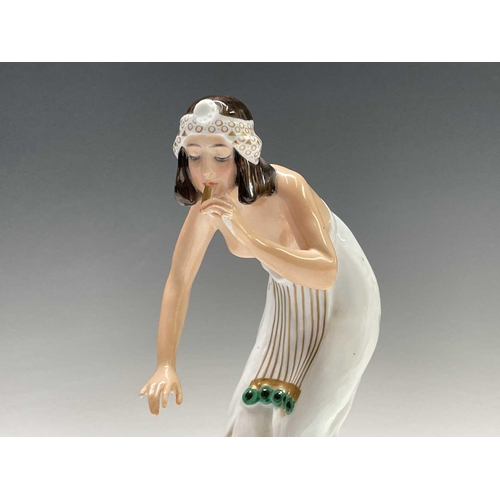 879 - A Rosenthal porcelain figure of a snake charmer, decorated in green and gilt, designed by Berthold B... 