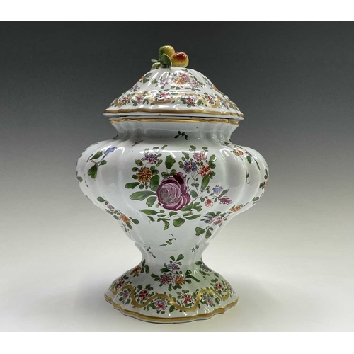 887 - An armorial tin glaze pottery jar and cover, circa 1900, with floral painted decoration, height 26cm... 