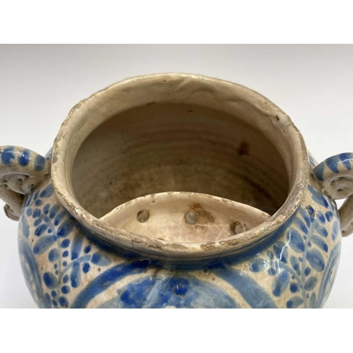 895 - A Continental tin glazed pottery strainer bowl, perhaps Spanish, 17th/18th century, with simple scro... 